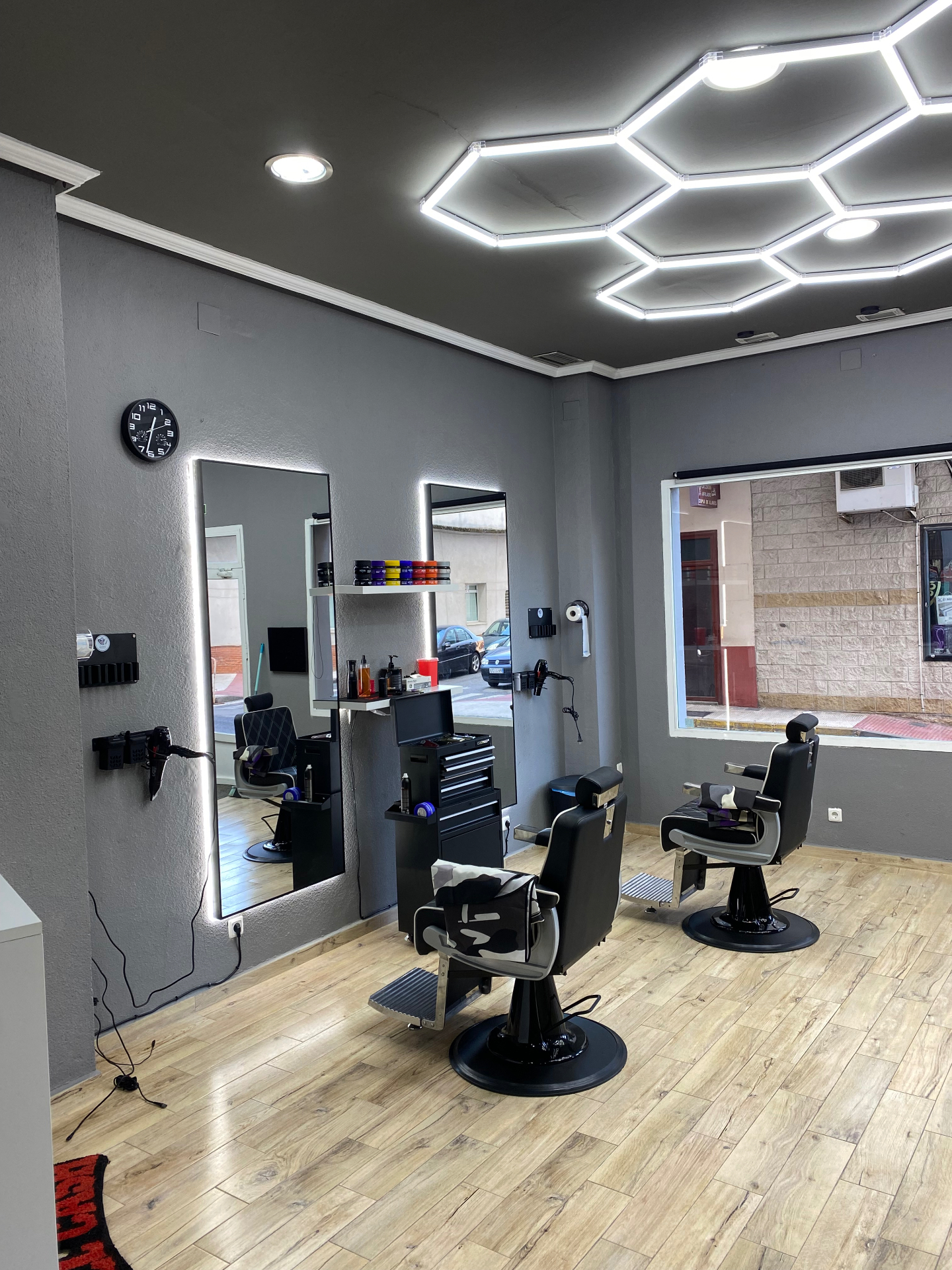 Interior de Latre BarberShop: sillones de barbero e iluminación hexagonal LED